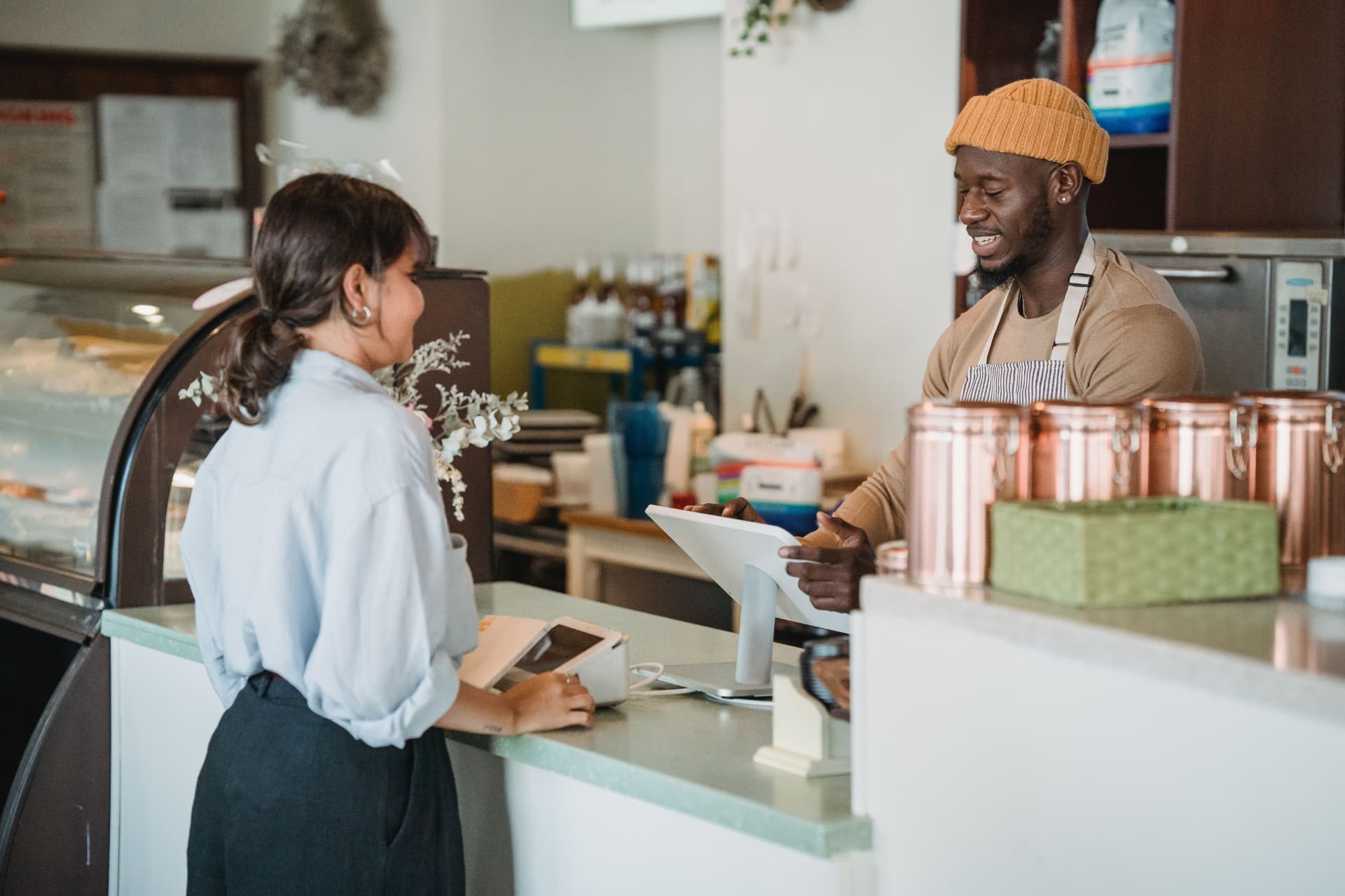 Barista melayani pelanggan di kasir coffee shop